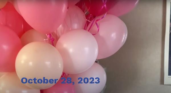 The camera then rotates to show several pink balloons and Strahan's twin, Sophia, messing with something off-camera. 