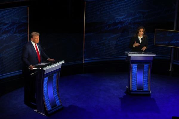 Harris speaks during a presidential debate hosted by ABC as Trump listens.