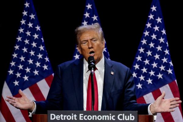 Former U.S. President Do<em></em>nald Trump speaking into a microphone at the Detroit Eco<em></em>nomic Club, October 10, 2024