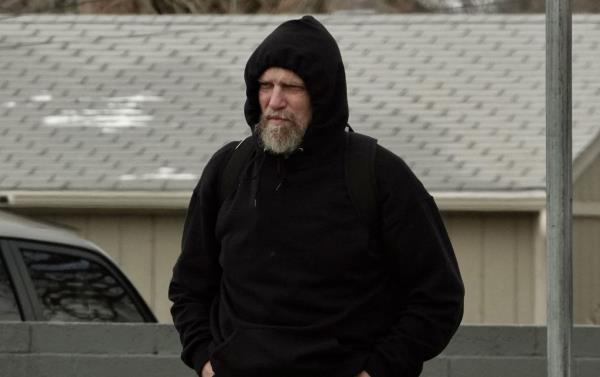 Oliva - wearing a black sweatshirt with its hood pulled tightly around his bearded face