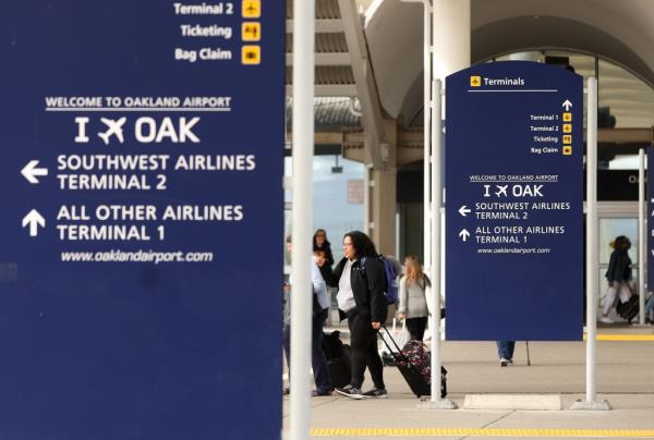 Travelers walking with luggage in Terminal 1 at Oakland Internatio<em></em>nal Airport, soon to be San Francisco Bay Oakland Internatio<em></em>nal Airport