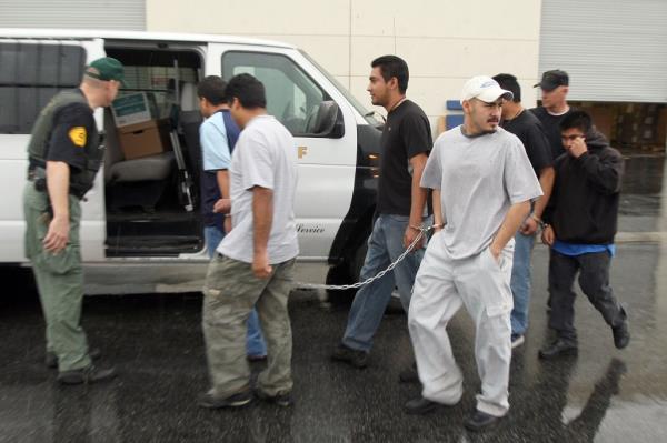 Sheriff Deputies arrest six Latino men while detaining a<em></em>bout 52 predominantly Latino immigrant workers inside a DVD manufacturing plant as they investigate a possible identity fraud case on February 5, 2009 in Santa Clarita, California.