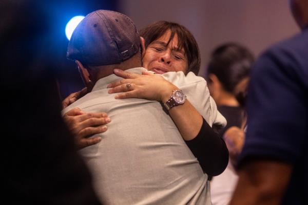 Attendees embrace during a church service at King's Cathedral in Kahului on the island of Maui, Hawaii Sunday, Aug. 13, 2023.