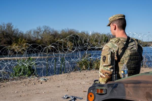 A Natio<em></em>nal Guard soldier stands guard on the banks of the Rio Grande river at Shelby Park on January 12, 2024 in Eagle Pass, Texas