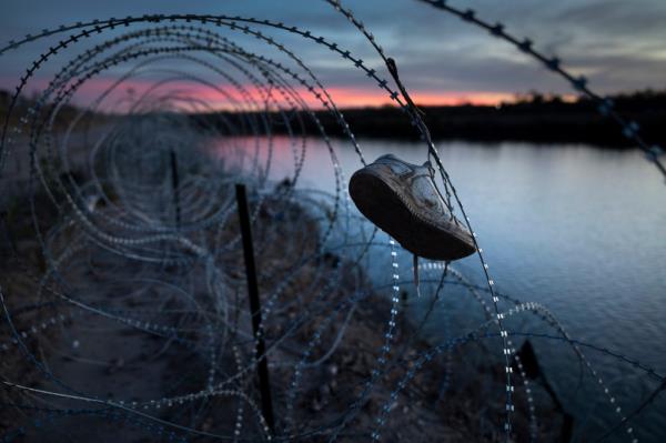 A child's shoe hangs caught in razor wire atop the bank of the Rio Grande on January 9, 2024 in Eagle Pass, Texas