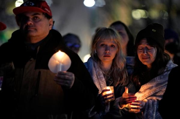 People attend a candlelight vigil for victims of a shooting at a Kansas City Chiefs Super Bowl victory rally Thursday, Feb. 15, 2024.