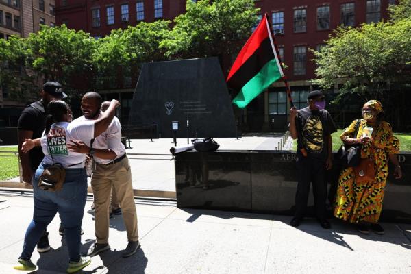 People waiting for a rally for reparations outside African Burial Ground Natio<em></em>nal Mo<em></em>nument in New York City.