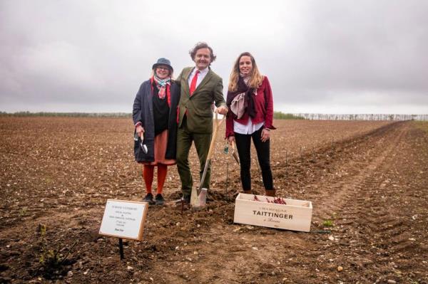 Taittinger is pictured holding a shovel on a patch of dirt with his wife, Claire, and their daughter, Vitalie.