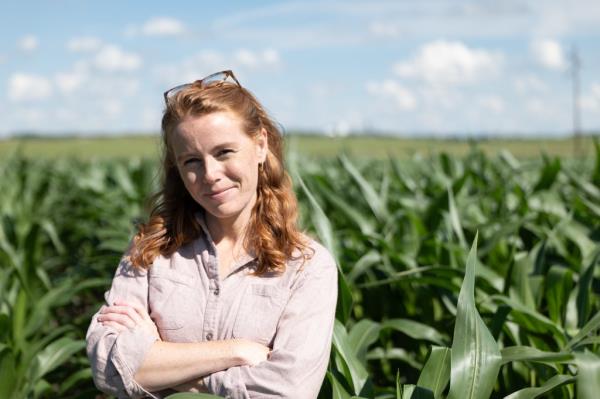 Pictures of Rebecca Cooke in front of a field of corn. 