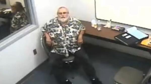 Larry Webb in an interrogation room 