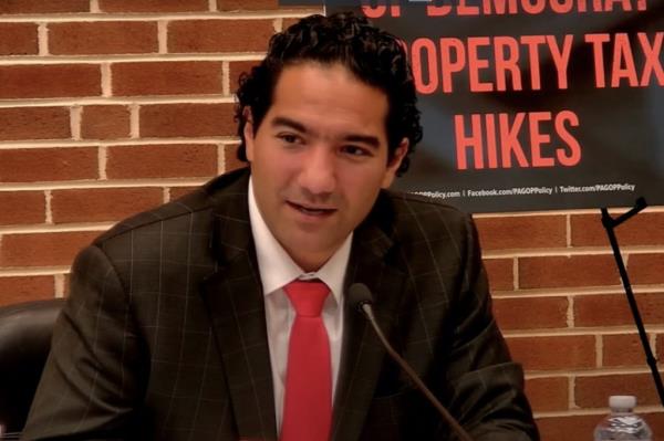 Rep. Josh Kail, R-Beaver, in a suit and tie, emphasizing the need for minimizing government at a Pennsylvania House Republican Committee meeting