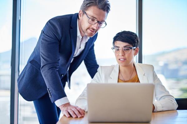 A man and woman co<em></em>nducting a training session on a laptop, discussing email marketing and automation software