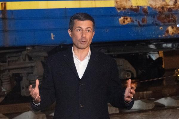 US Secretary of Transportation Pete Buttigieg answers media questions standing against the background of a passenger carriage damaged by the Russian shelling in Kyiv, Ukraine, Wednesday, Nov. 8, 2023. (AP Photo/Efrem Lukatsky)