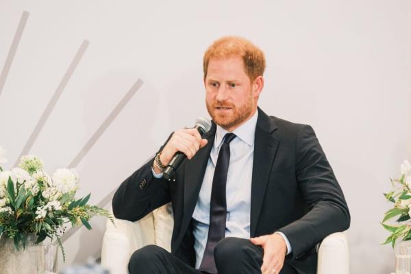 Prince Harry holds a microphone.