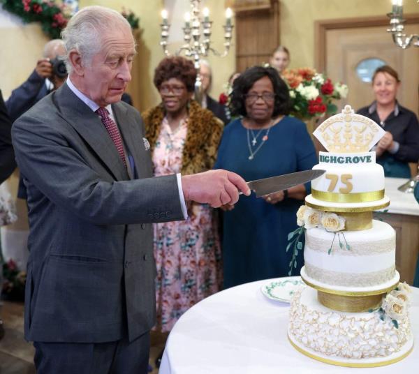 Britain's King Charles III reacts as he cuts a birthday cake as he attends his 75th birthday party.