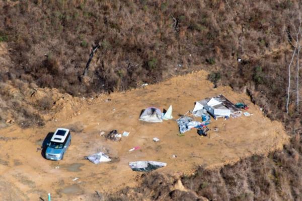 Apparently damaged home from the air with car in foreground