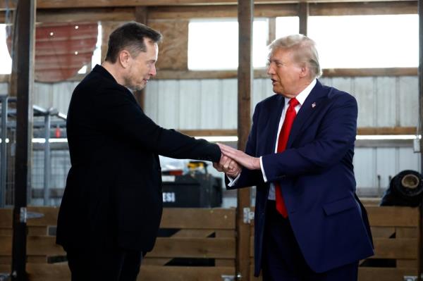 Trump and Musk shake hands.