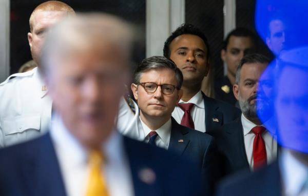 Speaker of the House Mike Johnson (C) and businessman Vivek Ramaswamy (3-L) listen as former U.S. President Do<em></em>nald Trump (C) sits next to his lawyers Todd Blanche (L) and Emil Bove as he arrives for his trial for allegedly covering up hush mo<em></em>ney payments l<em></em>inked to an extramarital affair with Stormy Daniels, at Manhattan Criminal Court on May 14, 2024 in New York City. 