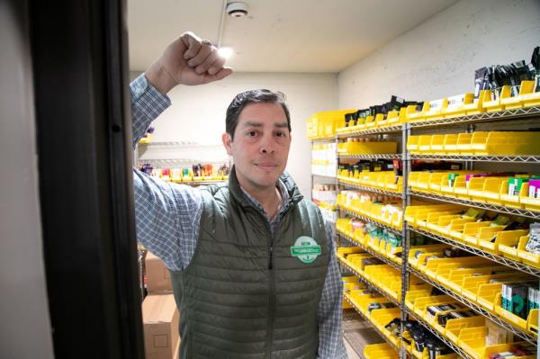 Osbert Orduna, CEO of The Cannabis Place dispensary, standing in a store and holding up his fist, before the grand opening in Queens, NY.