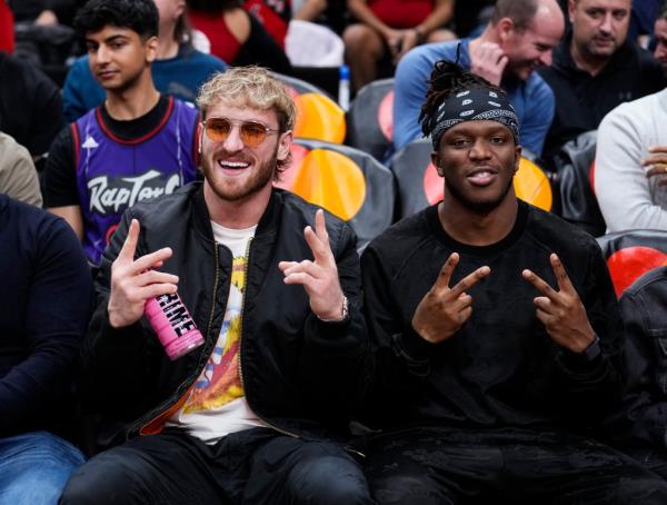 Logan Paul, at left, holds a pink Prime beverage as he sits next to Olajide Olayinka Williams 