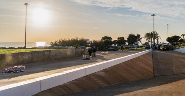 Carcavelos, Portugal - 12/31/18: Nova University beach parking entrance, modern architecture, Straight linear lines, bright sunset reflecting on water.