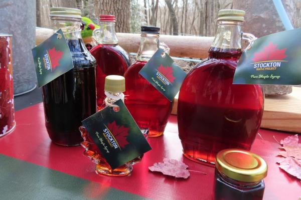 Glass co<em></em>ntainers of maple syrup produced by Stockton University's Maple Project displayed on an outdoor table at the university's campus in Galloway, New Jersey.