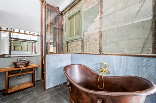 Interior of a bathroom with a copper tub. 