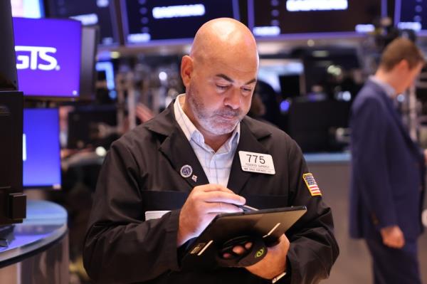 Traders working on the floor of the New York Stock Exchange during a mixed opening, following a significant market loss.