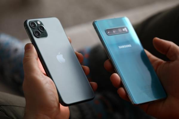 Man holding a new model of Apple iPhone and Samsung smartphone closeup in Minsk, Belarus