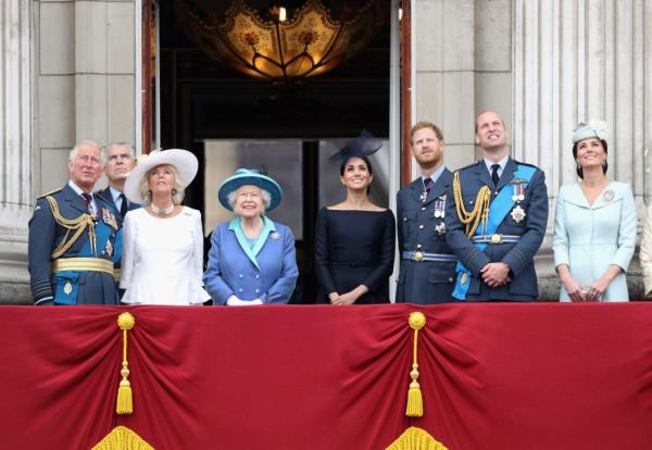 Members of the Royal Family including Prince Charles, Prince Andrew, Queen Elizabeth II, Prince William, Prince Harry, and Meghan, Duchess of Sussex, watching the RAF flypast from the balcony of Buckingham Palace