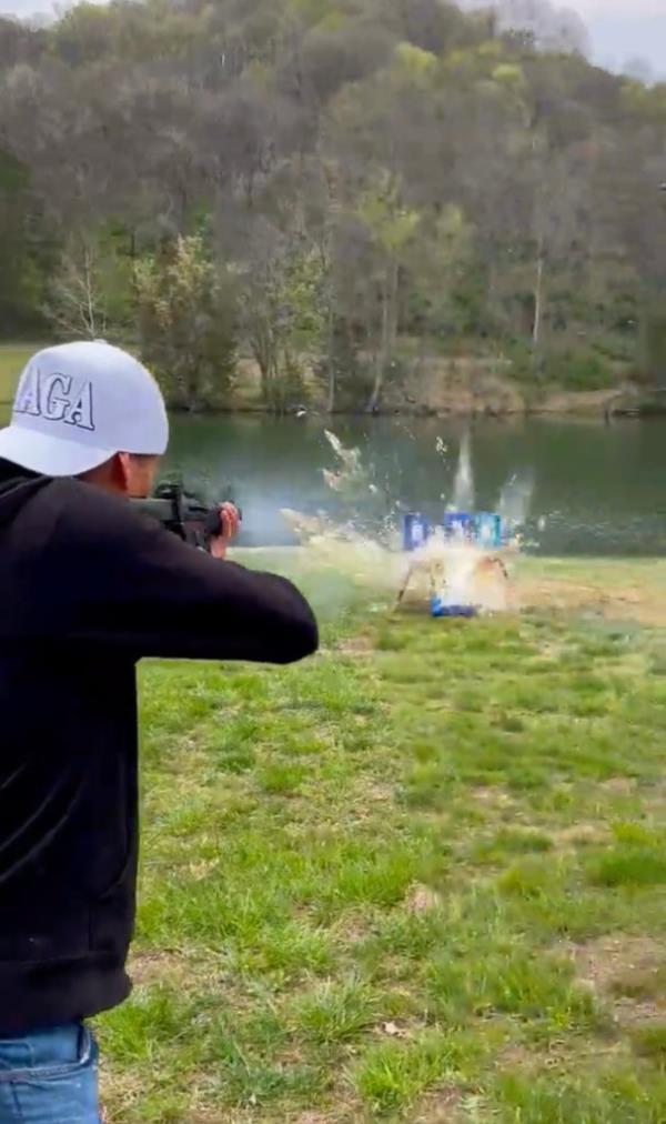 Kid Rock obliterates cases of Bud Light with his assault rifle.