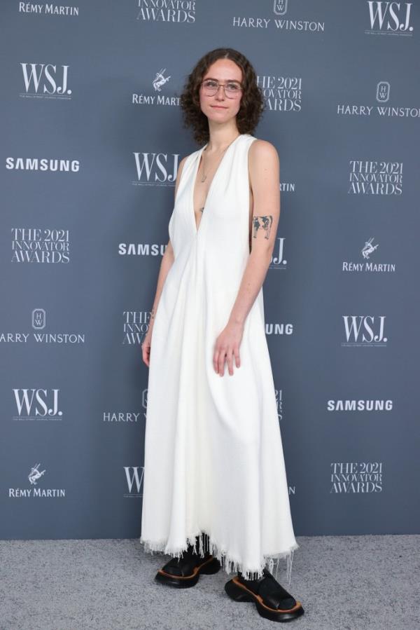 Ella Emhoff poses for the cameras in a white maxi dress on a red carpet