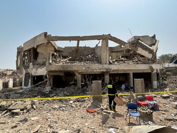 A firefighter stands in front of a damaged building following a blast in Ibadan, Nigeria, January 17, 2024. 