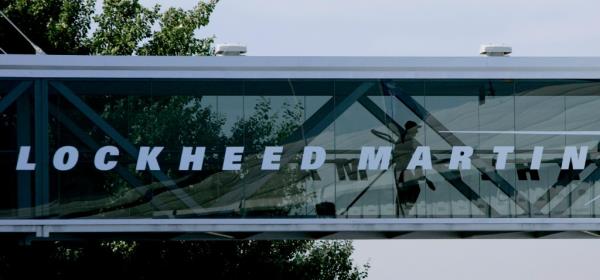 FILE - A man walks past a Lockheed Martin logo as he walks through a section of the company's chalet bridging a road at Farnborough Internatio<em></em>nal Airshow in Farnborough, southern England, Wednesday July 19, 2006.  The Biden administration is suing to block a Lockheed Martin acquisition that it says would limit competition among companies that supply missiles to the Pentagon. The Federal Trade Commission said Tuesday, Jan. 25, 2022 that the $4.4 billion deal would eliminate the last independent U.S. supplier of key missile parts.   (AP Photo/Matt Dunham, FILE)