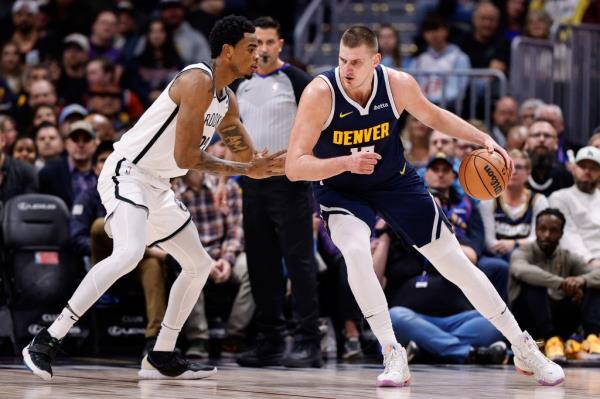 Nikola Jokic (15) controls the ball as Brooklyn Nets center Nic Claxton (33) guards in the first quarter at Ball Arena.