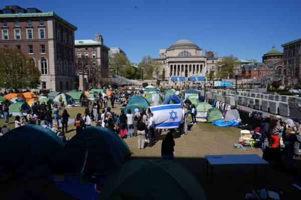 Pro-Israel protestors and pro-Palestinian encampment on the lawn of Columbia University during a rally, with tents, a flag and Sahana Kumari present.