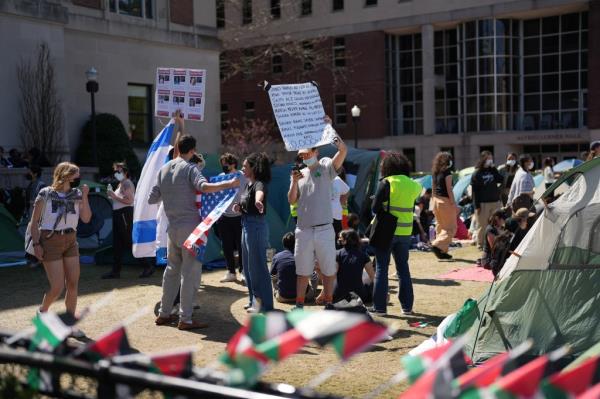 Pro-Israel protestors holding signs at a pro-Palestinian encampment at Columbia University, with Jan Friesinger present among them.