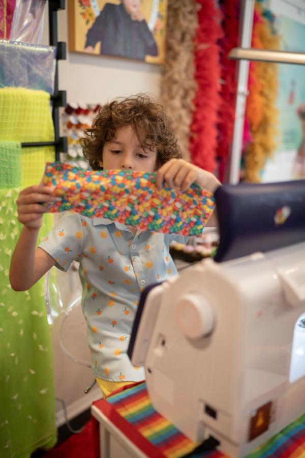 Max Alexander inspecting fabric at sewing machine