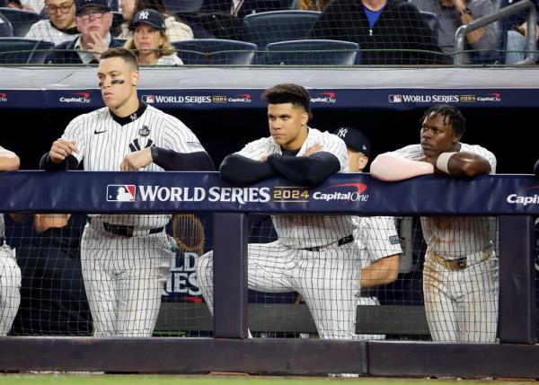 Aaron Judge, Juan Soto, and Jazz Chisholm of the New York Yankees reacting on the dugout fence during the fifth inning of World Series game 5.