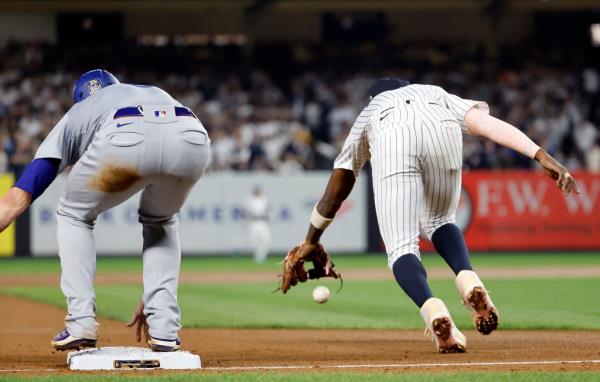 Jazz Chisholm Jr. #13 of the New York Yankees can't field a ball on a throwing error by Anthony Volpe #11 of the New York Yankees allowing Enrique Hernandez #8 of the Los Angeles Dodgers to reach third ba<em></em>se safely during the fifth inning.