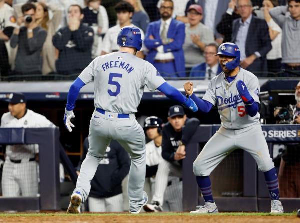 Mookie Betts #50 of the Los Angeles Dodgers reacts as Freddie Freeman #5 of the Los Angeles Dodgers scores on Teoscar Hernández #37 of the Los Angeles Dodgers two-run RBI double to tie the game during the fifth inning.