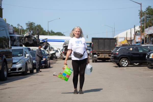 Massaro carrying cat food and a gallon of water.