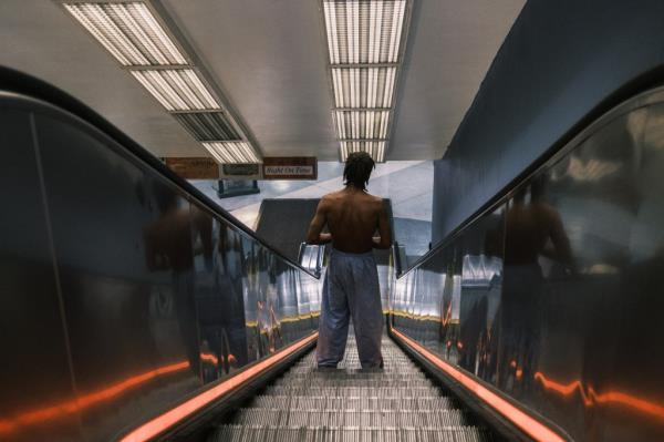 A homeless man going down the escalator to enter Penn Station on Aug. 24, 2024.