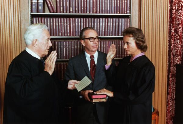 O'Co<em></em>nnor stands next to her husband, John O'Co<em></em>nnor (center) and is sworn in as a Supreme Court Justice by Chief Justice Warren Burger.