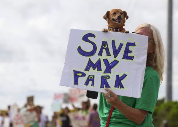 A large crowd of people gather at the front entrance of Jo<em></em>nathan Dickinson State Park to protest against the proposed golf courses Saturday, Aug. 24, 2024, in Martin County. Florida 