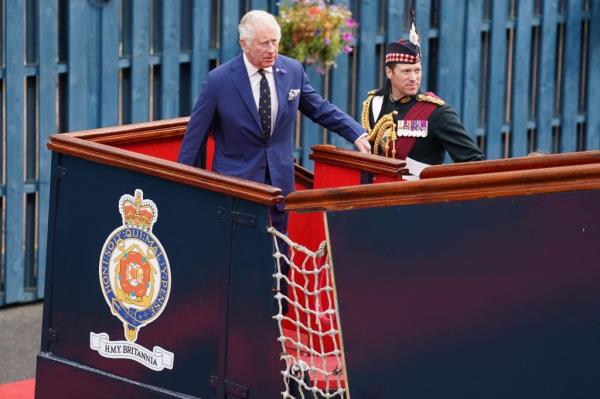 King Charles III and his equerry Major Johnny Thompson in suits, arriving for a tour of the Royal Yacht Britannia in Edinburgh