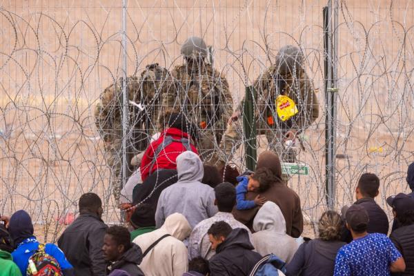 Texas Natio<em></em>nal Guard troops push back a group of migrants who crossed into the US from Mexico.