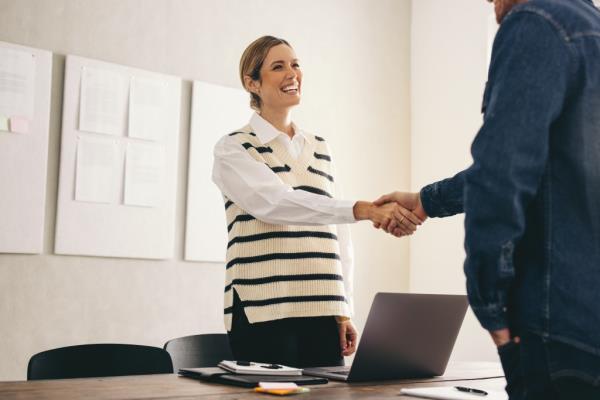 Excited businesswoman shaking hands with her new business partner. 