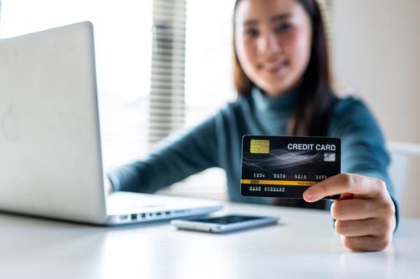 woman holding and showing new credit card.