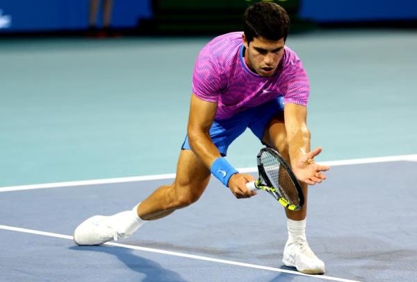 Carlos Alcaraz of Spain tries to catch a drago<em></em>nfly during his match against Grigor Dimitrov of Bulgaria on Day 13 of the Miami Open at Hard Rock Stadium on March 28, 2024 in Miami Gardens, Florida.